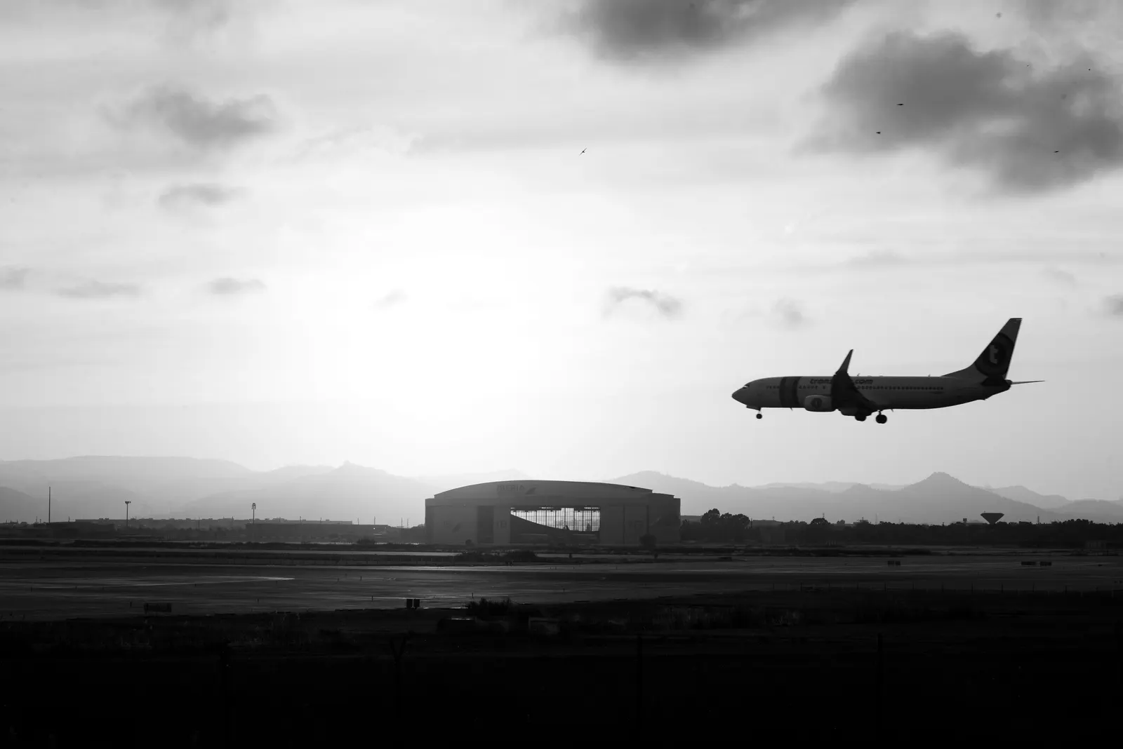 Freight aircraft landing at an airport at dusk