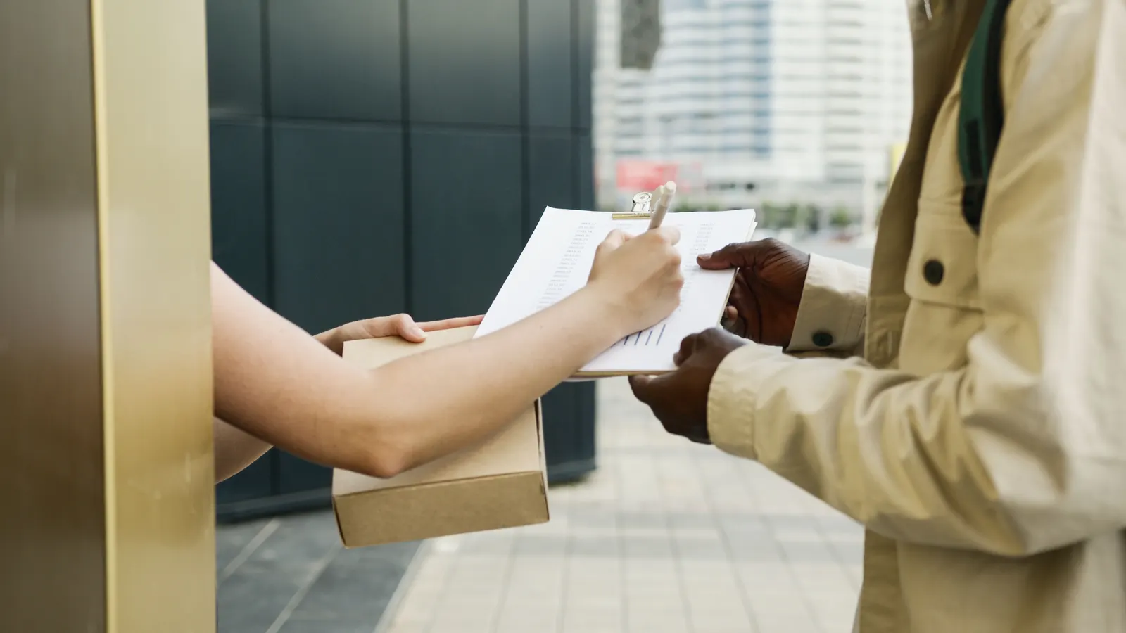 Courier handing a parcel to a customer and taking a signature