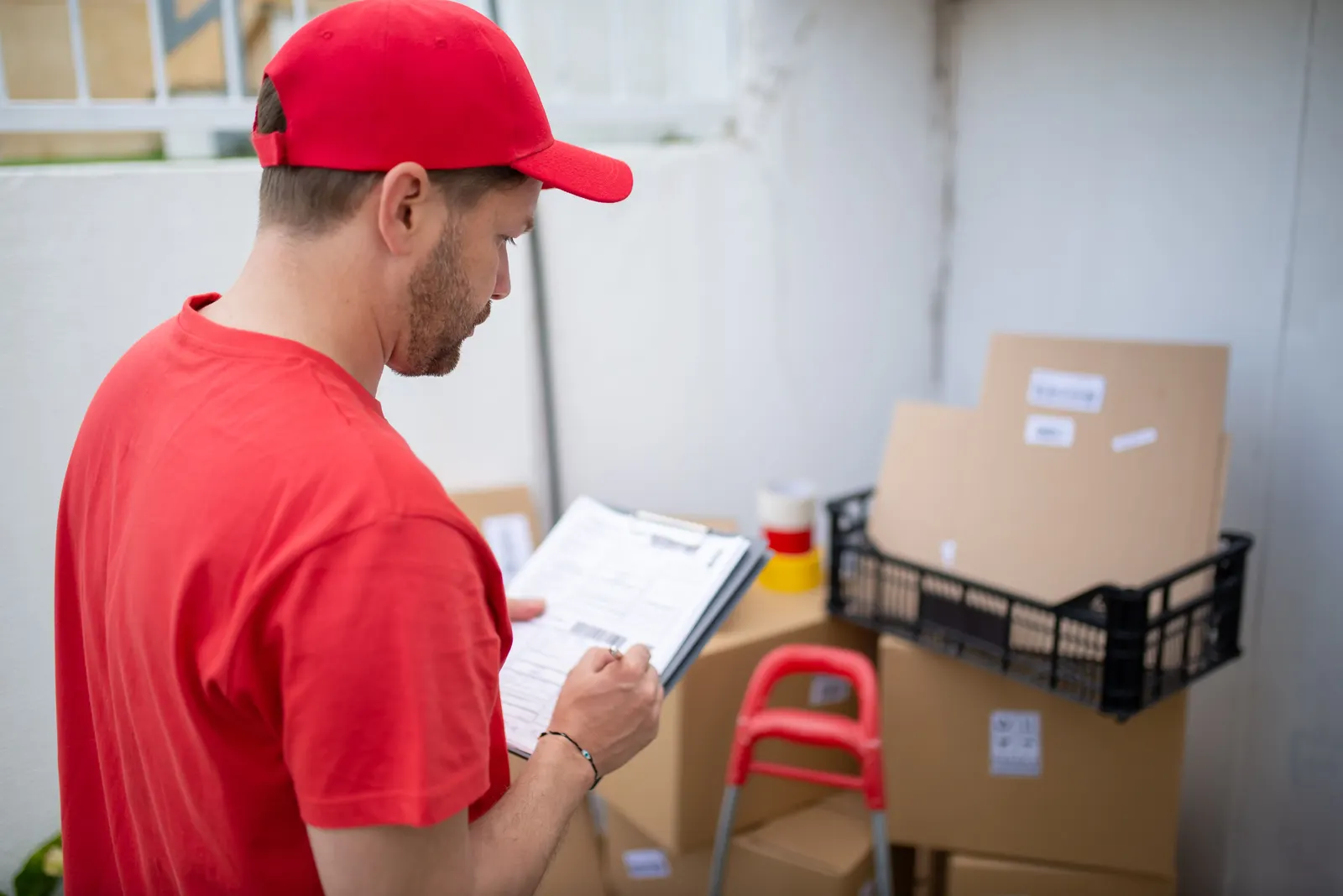 Courier checking a shipping label against a manifest
